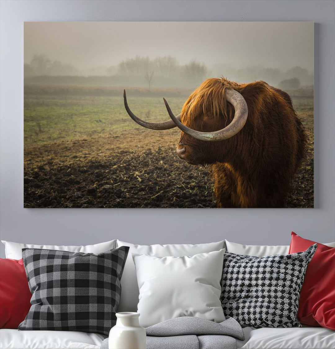 The "Big Cow Horn Wall Art Canvas Print" is a hand-assembled framed canvas depicting a Highland cow in a misty field. It is crafted with a UV-protective coating to ensure lasting vibrancy.