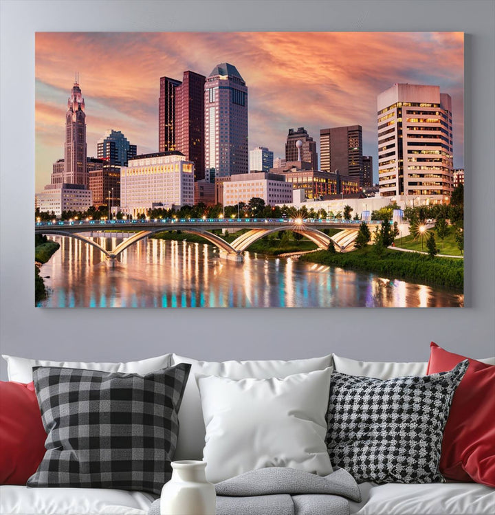 The "Columbus City Lights Sunset Orange Cloudy Skyline Cityscape View" wall art is featured on the wall. This triptych is printed on museum-quality canvas and includes a UV-protective coating, ensuring lasting vibrancy.