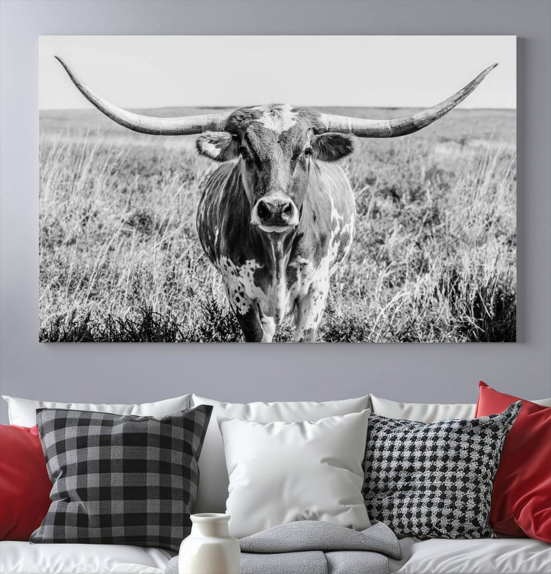 The Texas Cow Longhorn Wall Art Canvas Print is a black and white triptych depicting a cow in a field. It is crafted with museum-quality canvas and features a UV-protective coating.