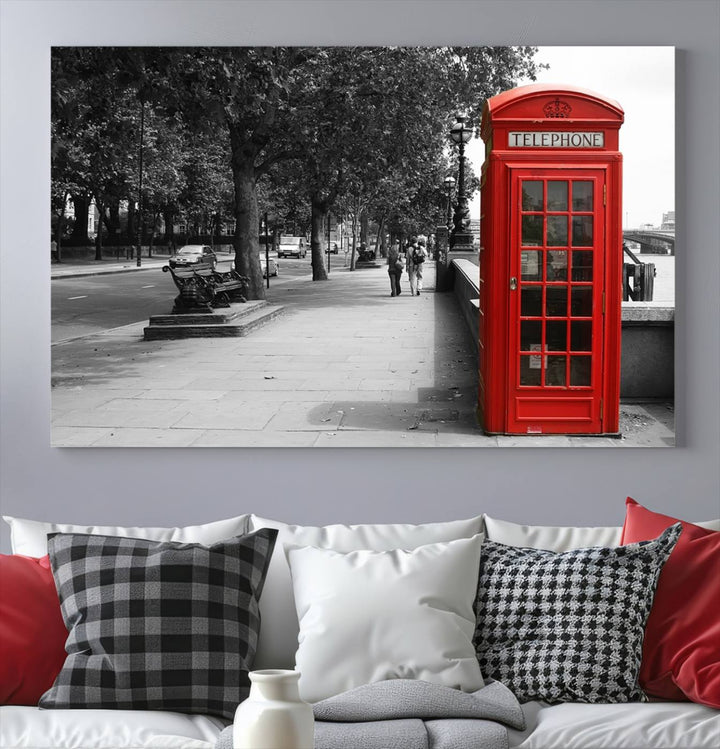 The London Phone Club Wall Art is a stunning piece that showcases a red telephone box set in a black and white street scene on museum-quality canvas. It is gallery wrapped with a UV-protective coating to preserve its vibrant charm.