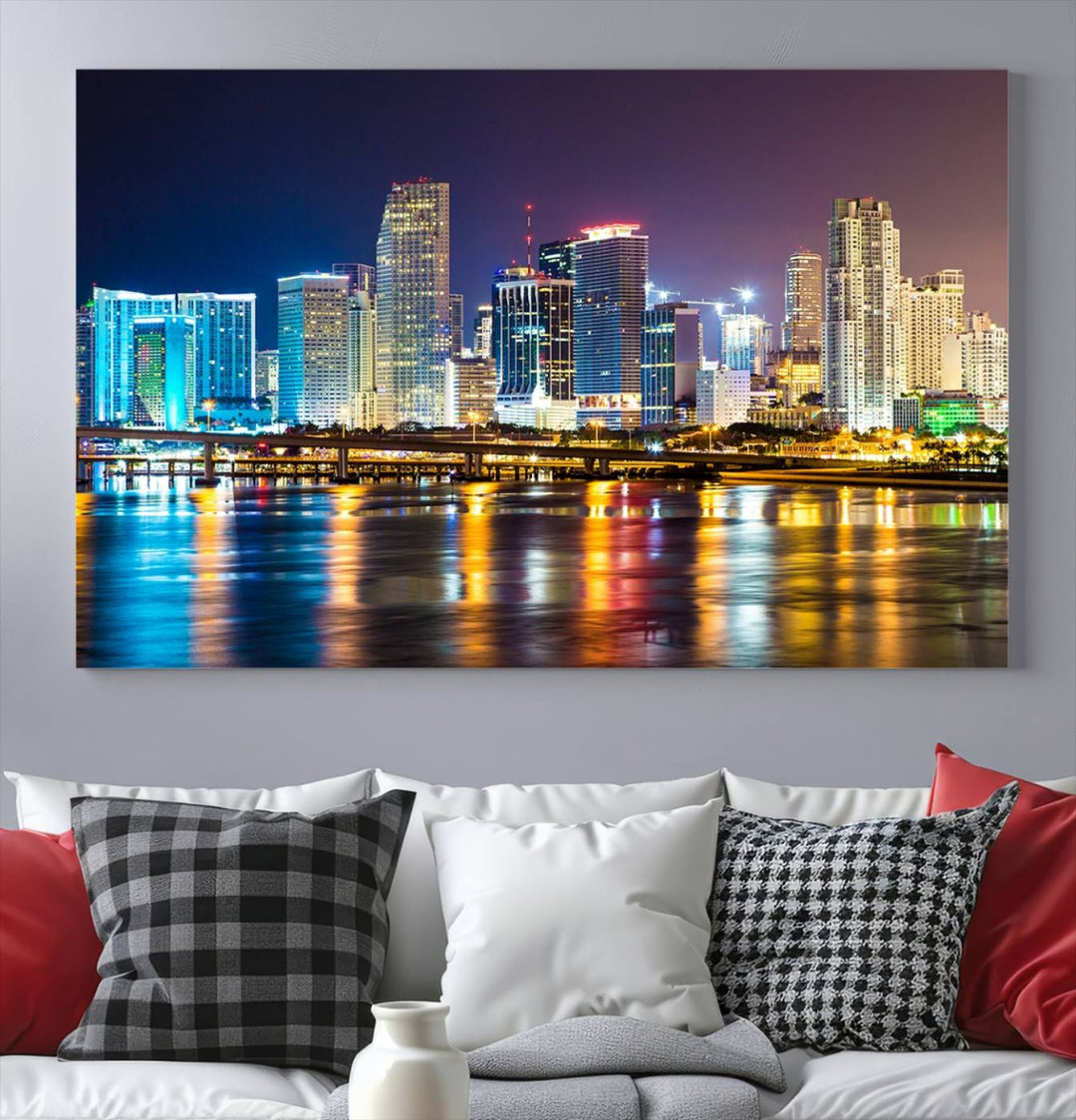 The Wall Art MIAMI Canvas Print features a stunning triptych of a city skyline at night, with vibrant lights reflecting on the water. This gallery-wrapped piece on museum-quality canvas delivers an exquisite finish.