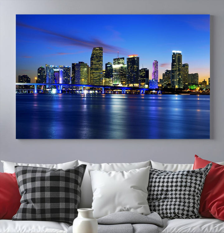 The modern living room showcases a striking Miami Blue Night Wall Art canvas print on the wall. The artwork is gallery wrapped on museum-quality canvas, ensuring durability and elegance.