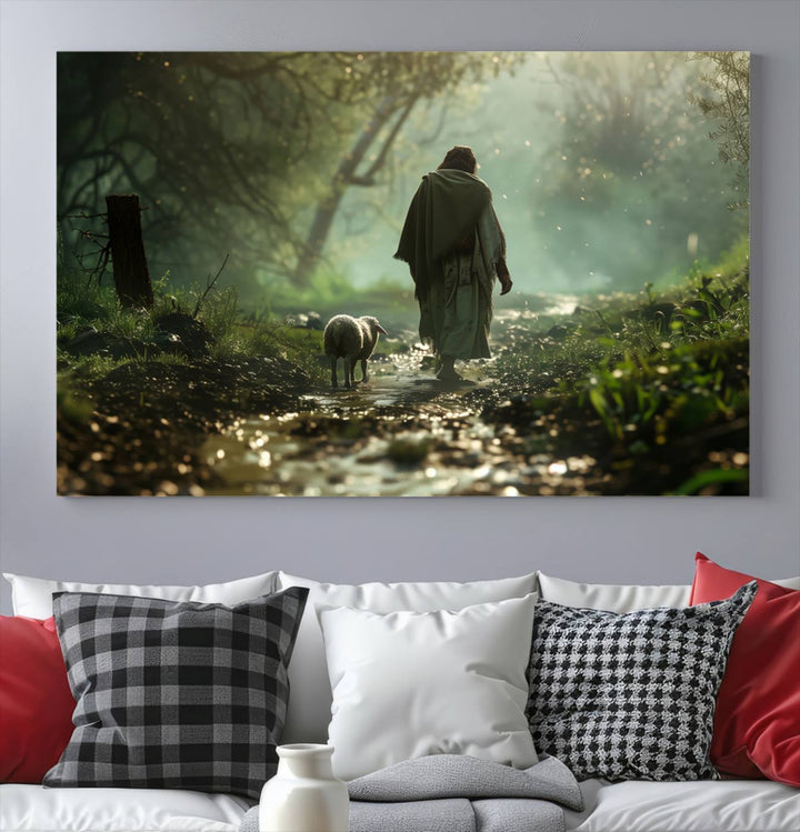 The wall art piece, titled "Jesus Shepherd a Lost Lamb Canvas Wall Art Print," is suspended on the wall and depicts a robed figure and a lamb wandering along a forest path.