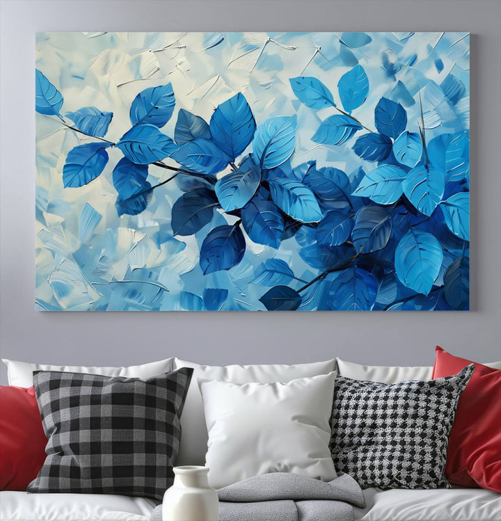 The contemporary living room is highlighted by the Abstract Blue Leaf Wall Art Canvas Print on the wall. The hand-assembled framed art enhances the room's vibrant decor, crafting a gallery-worthy ambience.