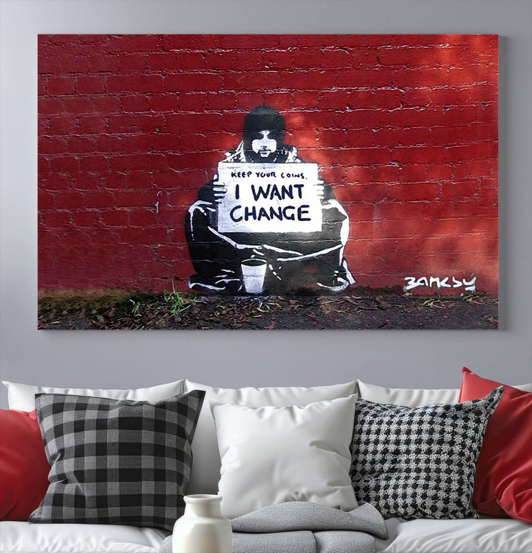 The living room showcases a triptych of stencil artwork on museum-quality canvas, featuring the Banksy I Want Change Graffiti Abstract Wall Art Canvas Print. This captivating piece depicts a person holding a sign that says "I want change" and is finished with a UV-protective coating to ensure long-lasting beauty.