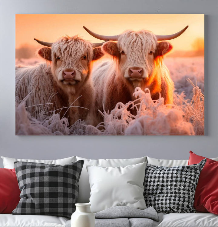 The "Highland Cows at Sunrise Wall Art Canvas Set" beautifully captures a serene and rustic farmhouse aesthetic, portraying two Highland cows in a frosty landscape at sunrise.