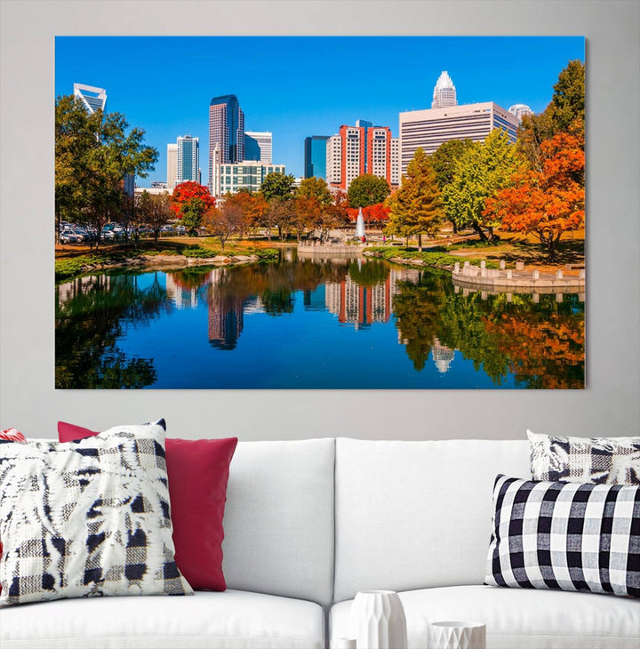 The "Charlotte City Autumn Morning Blue Skyline Cityscape View Wall Art Canvas Print" showcases a cityscape with vibrant autumn trees reflected in a lake. Its gallery-wrapped edges add depth to the scene, while the UV-protective coating ensures lasting brilliance.