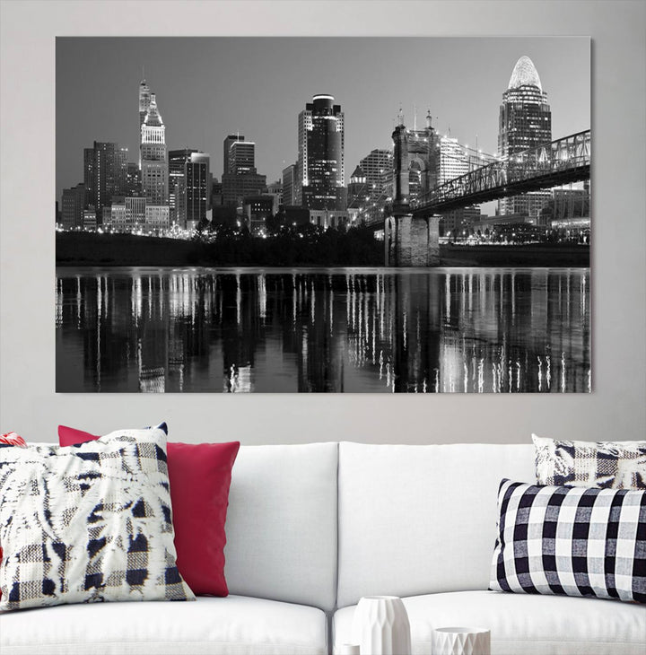 The wall showcases a ready-to-hang triptych of the Cincinnati City Lights Skyline in black and white, printed on museum-quality canvas.