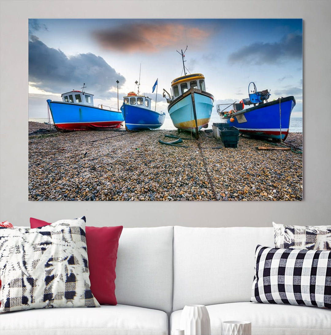 The "Big Boats On The Beach Wall Art Canvas Print" is a stunning piece featuring three museum-quality panels depicting fishing boats on a pebbled shore. Ready to hang and featuring UV-protective coating, it serves as an elegant addition to your home décor.