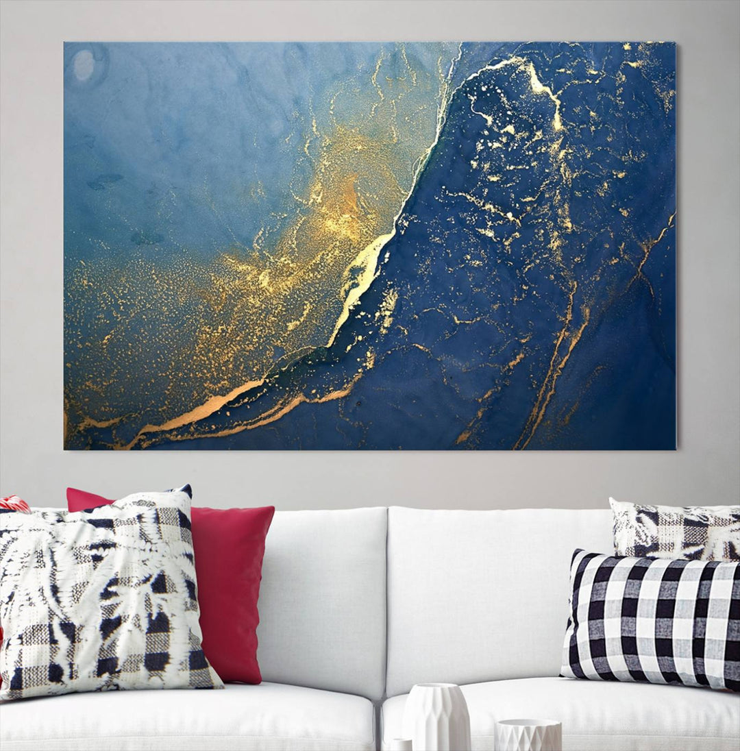 The Navy Blue Yellow Twinkle Wall Art Canvas Print, featuring an abstract design in gold and blue, enhances a modern living room as it adorns a white wall with its gallery-wrapped, museum-quality canvases for an exquisite touch.