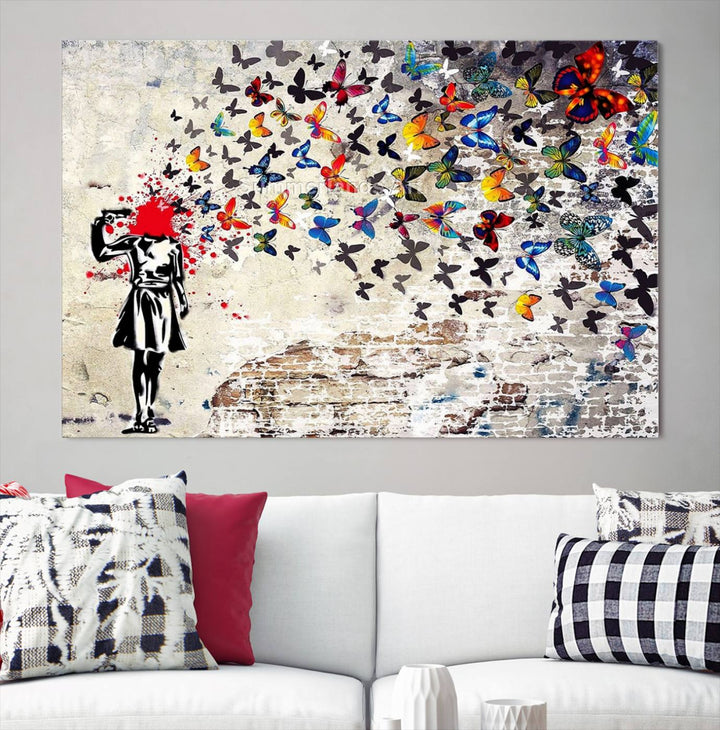 The Banksy Art Butterfly Girl Explosion Canvas showcases a dynamic figure with butterflies bursting from their head, set against a textured wall background. This vibrant urban graffiti piece is perfect for modern interiors and comes ready to hang.