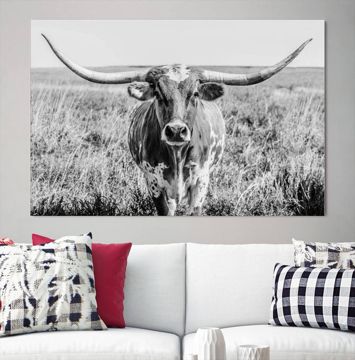 The Texas Cow Longhorn Wall Art Canvas Print is a black and white triptych depicting a cow in a field. It is crafted with museum-quality canvas and features a UV-protective coating.