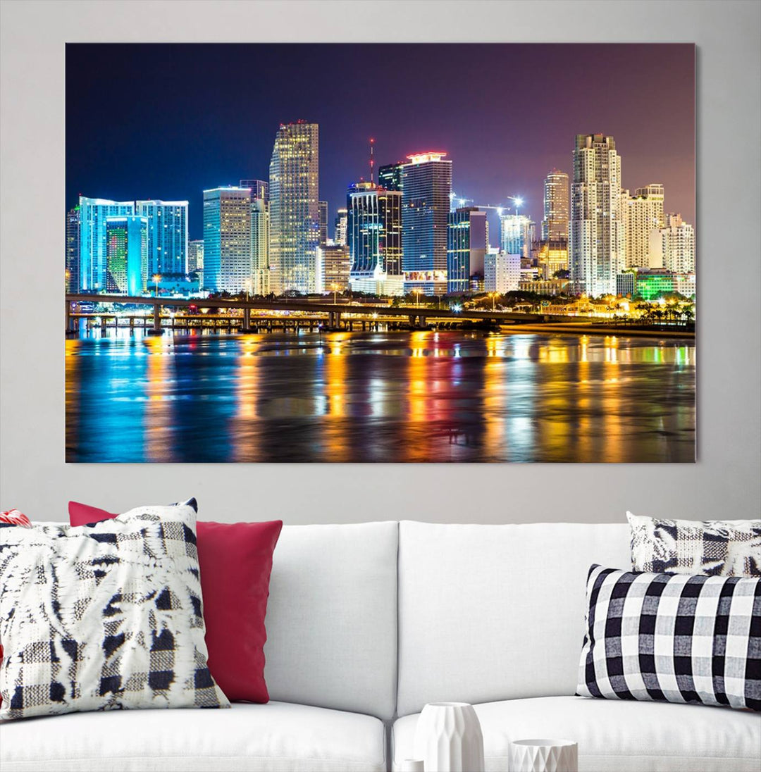 The Wall Art MIAMI Canvas Print features a stunning triptych of a city skyline at night, with vibrant lights reflecting on the water. This gallery-wrapped piece on museum-quality canvas delivers an exquisite finish.