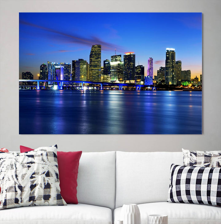 The modern living room showcases a striking Miami Blue Night Wall Art canvas print on the wall. The artwork is gallery wrapped on museum-quality canvas, ensuring durability and elegance.