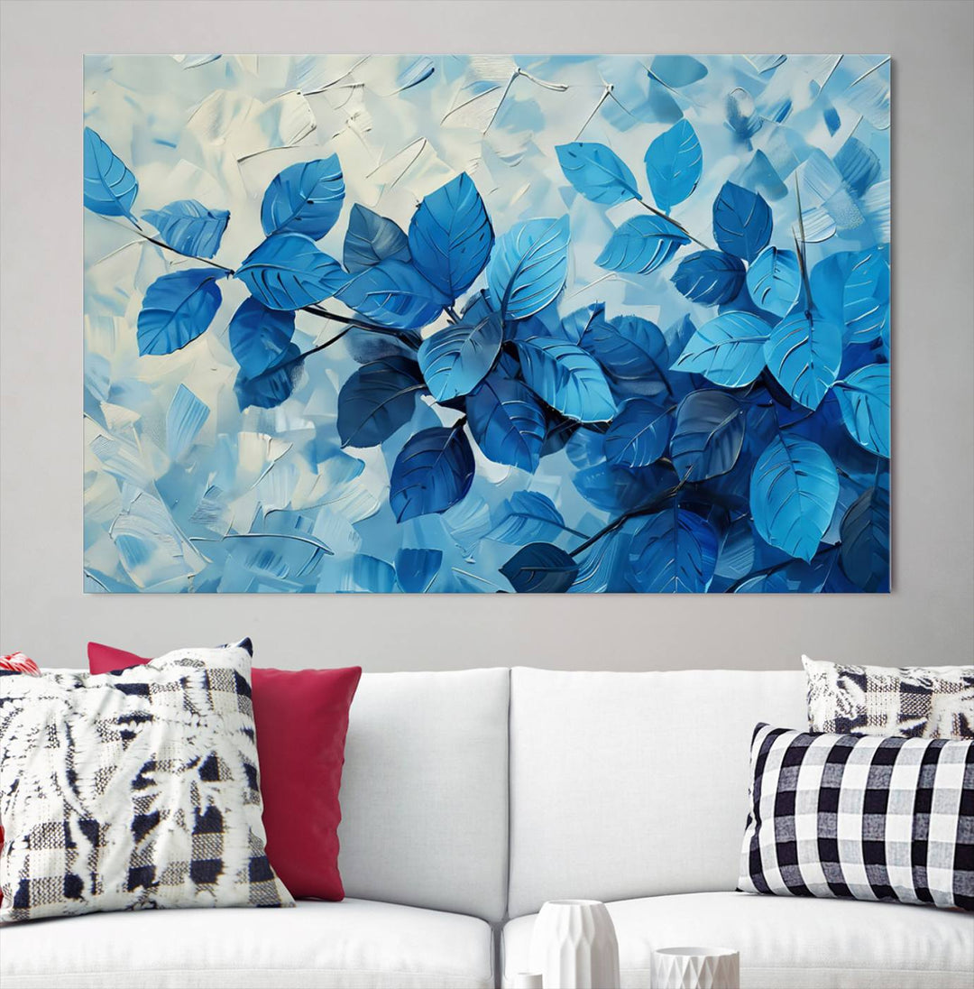 The contemporary living room is highlighted by the Abstract Blue Leaf Wall Art Canvas Print on the wall. The hand-assembled framed art enhances the room's vibrant decor, crafting a gallery-worthy ambience.