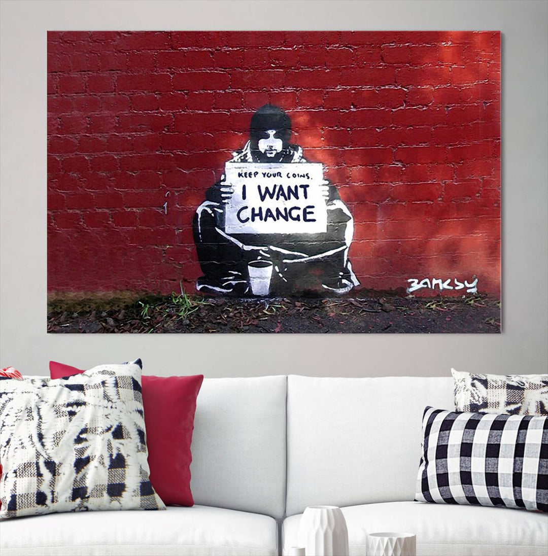 The living room showcases a triptych of stencil artwork on museum-quality canvas, featuring the Banksy I Want Change Graffiti Abstract Wall Art Canvas Print. This captivating piece depicts a person holding a sign that says "I want change" and is finished with a UV-protective coating to ensure long-lasting beauty.