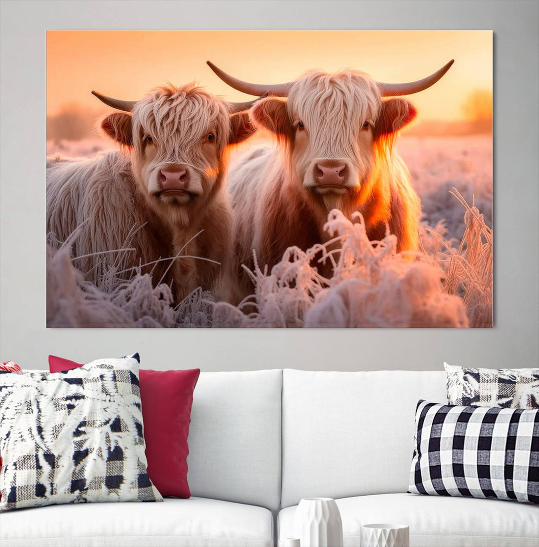 The "Highland Cows at Sunrise Wall Art Canvas Set" beautifully captures a serene and rustic farmhouse aesthetic, portraying two Highland cows in a frosty landscape at sunrise.