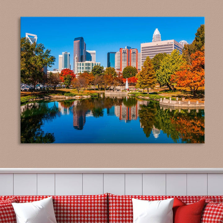 The "Charlotte City Autumn Morning Blue Skyline Cityscape View Wall Art Canvas Print" showcases a cityscape with vibrant autumn trees reflected in a lake. Its gallery-wrapped edges add depth to the scene, while the UV-protective coating ensures lasting brilliance.