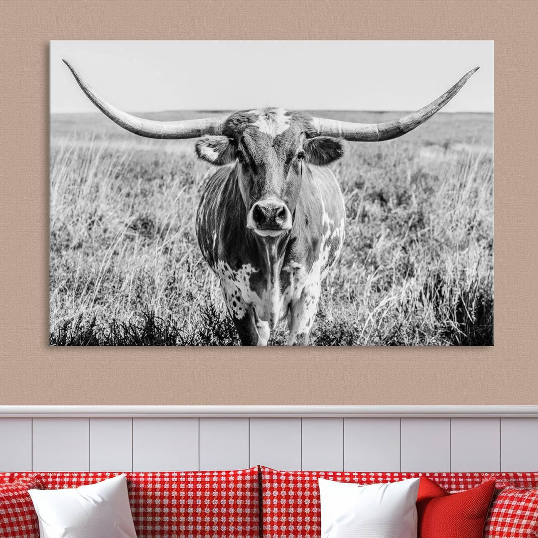 The Texas Cow Longhorn Wall Art Canvas Print is a black and white triptych depicting a cow in a field. It is crafted with museum-quality canvas and features a UV-protective coating.