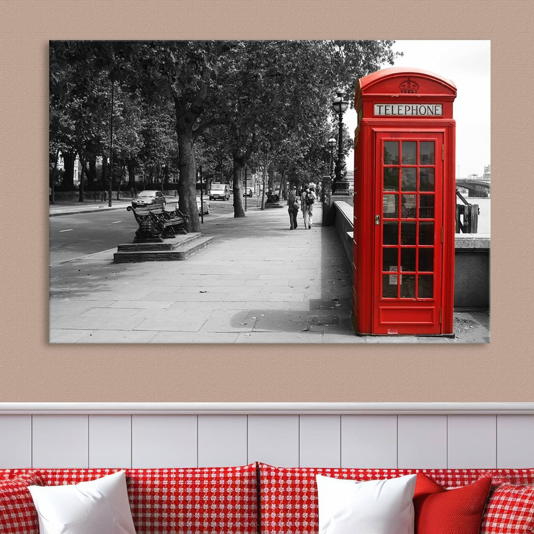 The London Phone Club Wall Art is a stunning piece that showcases a red telephone box set in a black and white street scene on museum-quality canvas. It is gallery wrapped with a UV-protective coating to preserve its vibrant charm.