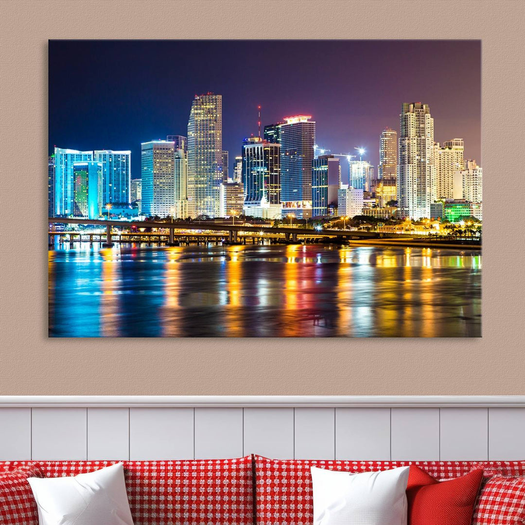 The Wall Art MIAMI Canvas Print features a stunning triptych of a city skyline at night, with vibrant lights reflecting on the water. This gallery-wrapped piece on museum-quality canvas delivers an exquisite finish.