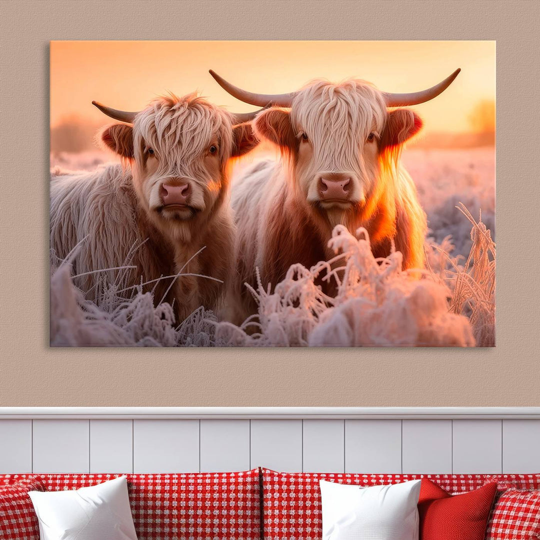 The "Highland Cows at Sunrise Wall Art Canvas Set" beautifully captures a serene and rustic farmhouse aesthetic, portraying two Highland cows in a frosty landscape at sunrise.