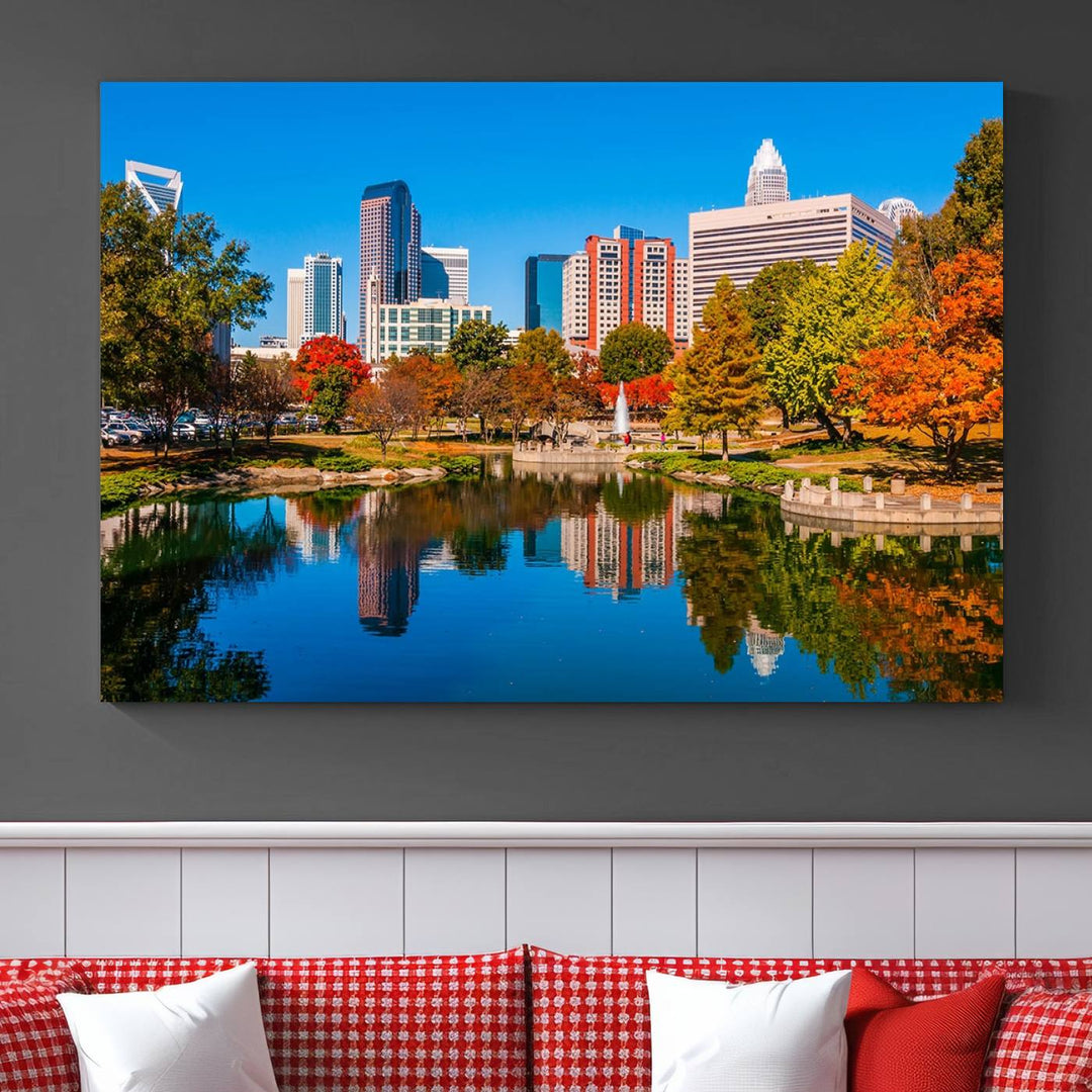 The "Charlotte City Autumn Morning Blue Skyline Cityscape View Wall Art Canvas Print" showcases a cityscape with vibrant autumn trees reflected in a lake. Its gallery-wrapped edges add depth to the scene, while the UV-protective coating ensures lasting brilliance.