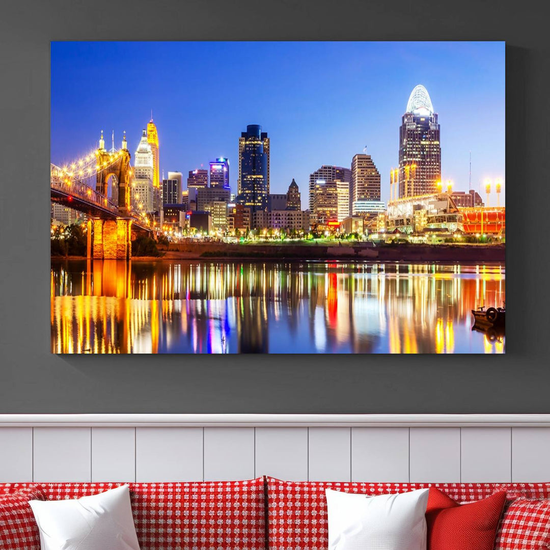 The "Cincinnati City Lights Night Skyline Cityscape View Wall Art Canvas Print" is a gallery-wrapped, museum-quality canvas illustrating a lit-up bridge and skyline at night. Enhanced with a UV-protective coating, this piece ensures lasting vibrancy.