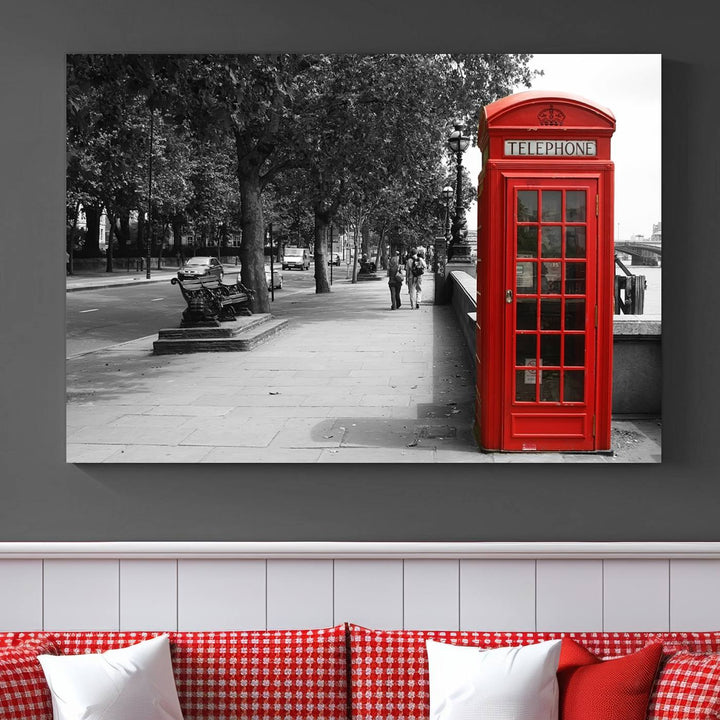 The London Phone Club Wall Art is a stunning piece that showcases a red telephone box set in a black and white street scene on museum-quality canvas. It is gallery wrapped with a UV-protective coating to preserve its vibrant charm.