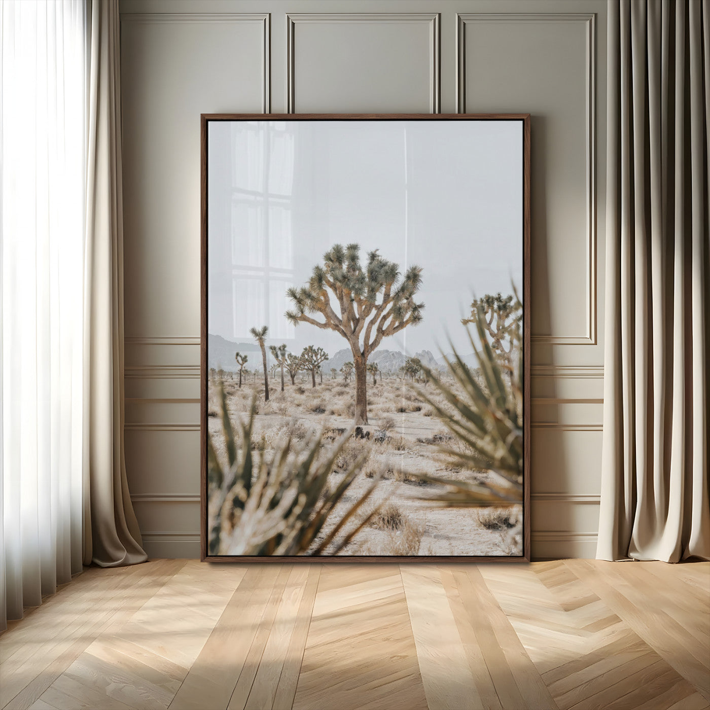 A wide desert landscape featuring multiple Joshua trees with spiky leaves and twisted branches, set against a pale sky and distant rocky hills. The foreground has blurred desert shrubs, emphasizing depth.