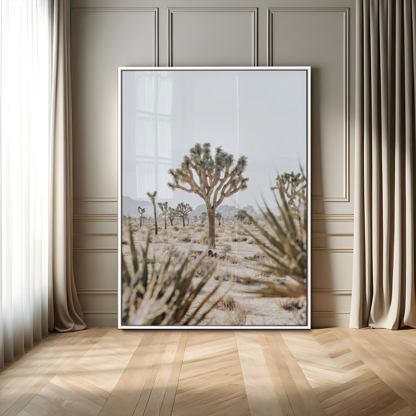 A wide desert landscape featuring multiple Joshua trees with spiky leaves and twisted branches, set against a pale sky and distant rocky hills. The foreground has blurred desert shrubs, emphasizing depth.