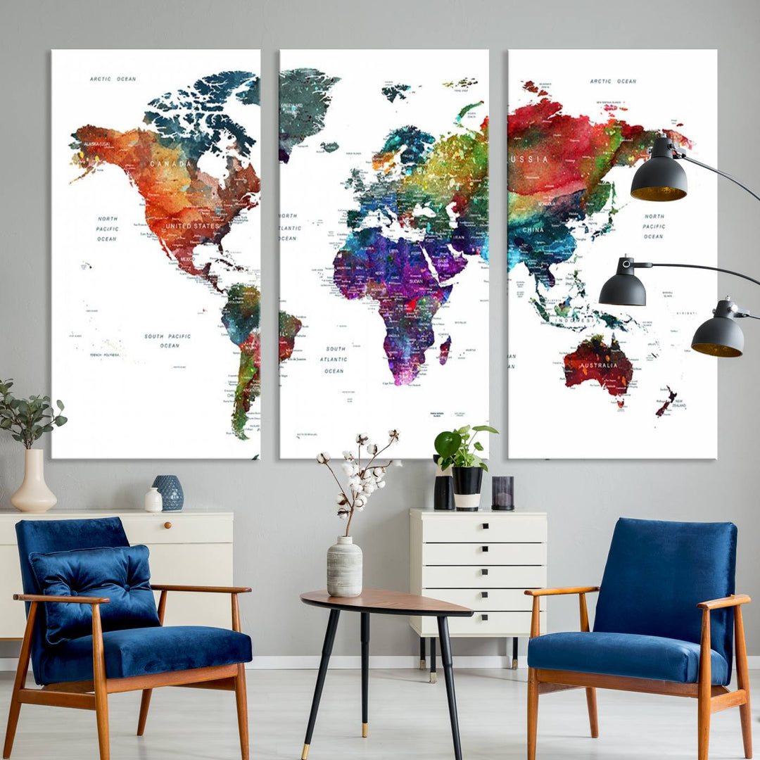 A three-panel Watercolor World Map Wall Art Print graces the wall of a modern living room. The Grunge Map Canvas Print introduces an element of timeless elegance to the space.