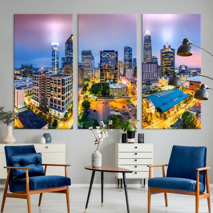 The living room features three large pieces of the *Charlotte City Lights Sunset Purple Skyline Cityscape View Wall Art Canvas Print*. Crafted on gallery-wrapped, museum-quality canvas with UV-protective coating, they grace the wall and add an artistic flair to the space.