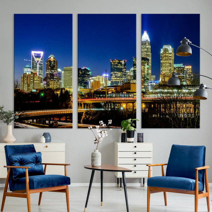 The Charlotte City Lights Night Blue Skyline Cityscape View Wall Art Canvas Print, showcasing an illuminated city skyline at night, is printed on museum-quality canvas with a UV-protective coating. Enhance your space with this stunning piece and enjoy free shipping with your purchase.