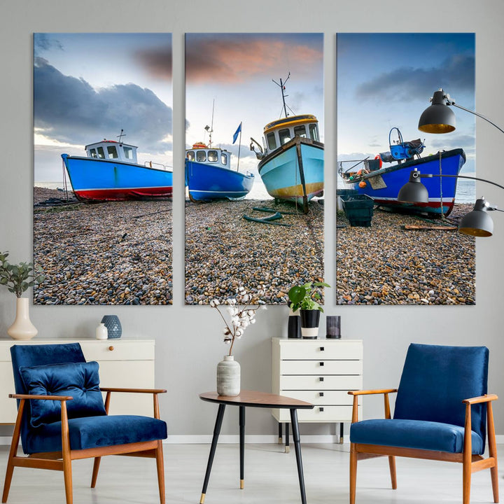 The "Big Boats On The Beach Wall Art Canvas Print" is a stunning piece featuring three museum-quality panels depicting fishing boats on a pebbled shore. Ready to hang and featuring UV-protective coating, it serves as an elegant addition to your home décor.