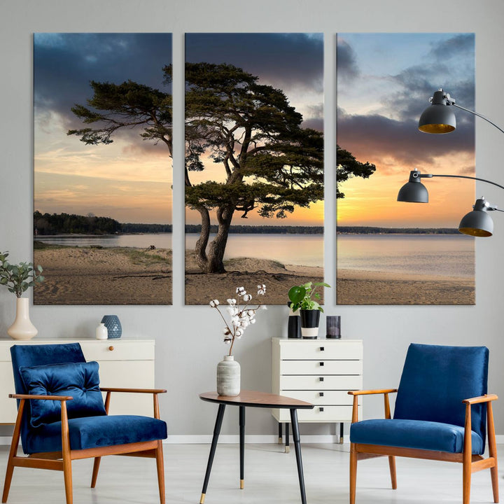 The room showcases the Coastal Sunset Wall Art Canvas Print, a triptych elegantly displayed on museum-quality polycotton canvas, depicting a serene beach sunset with a tree.