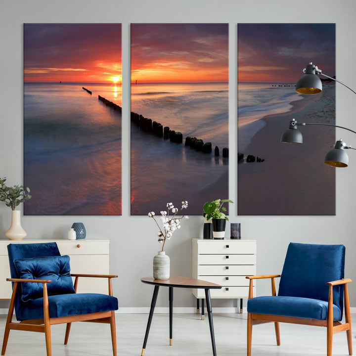 In a modern living room, the Sunset Beach Wall Art Canvas Print is displayed above. This triptych, printed on museum-quality canvas with a UV-protective coating, ensures lasting brilliance. It's ready to hang and brings an elegant touch to your space.