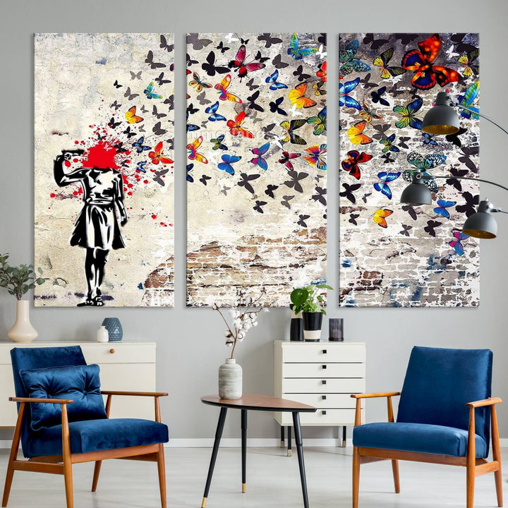 The Banksy Art Butterfly Girl Explosion Canvas showcases a dynamic figure with butterflies bursting from their head, set against a textured wall background. This vibrant urban graffiti piece is perfect for modern interiors and comes ready to hang.