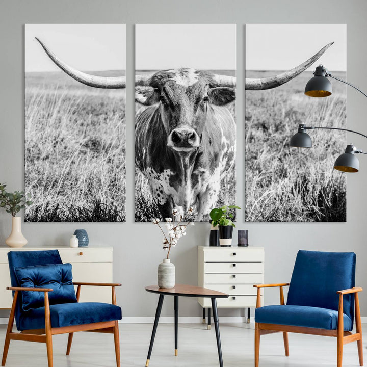 The Texas Cow Longhorn Wall Art Canvas Print is a black and white triptych depicting a cow in a field. It is crafted with museum-quality canvas and features a UV-protective coating.