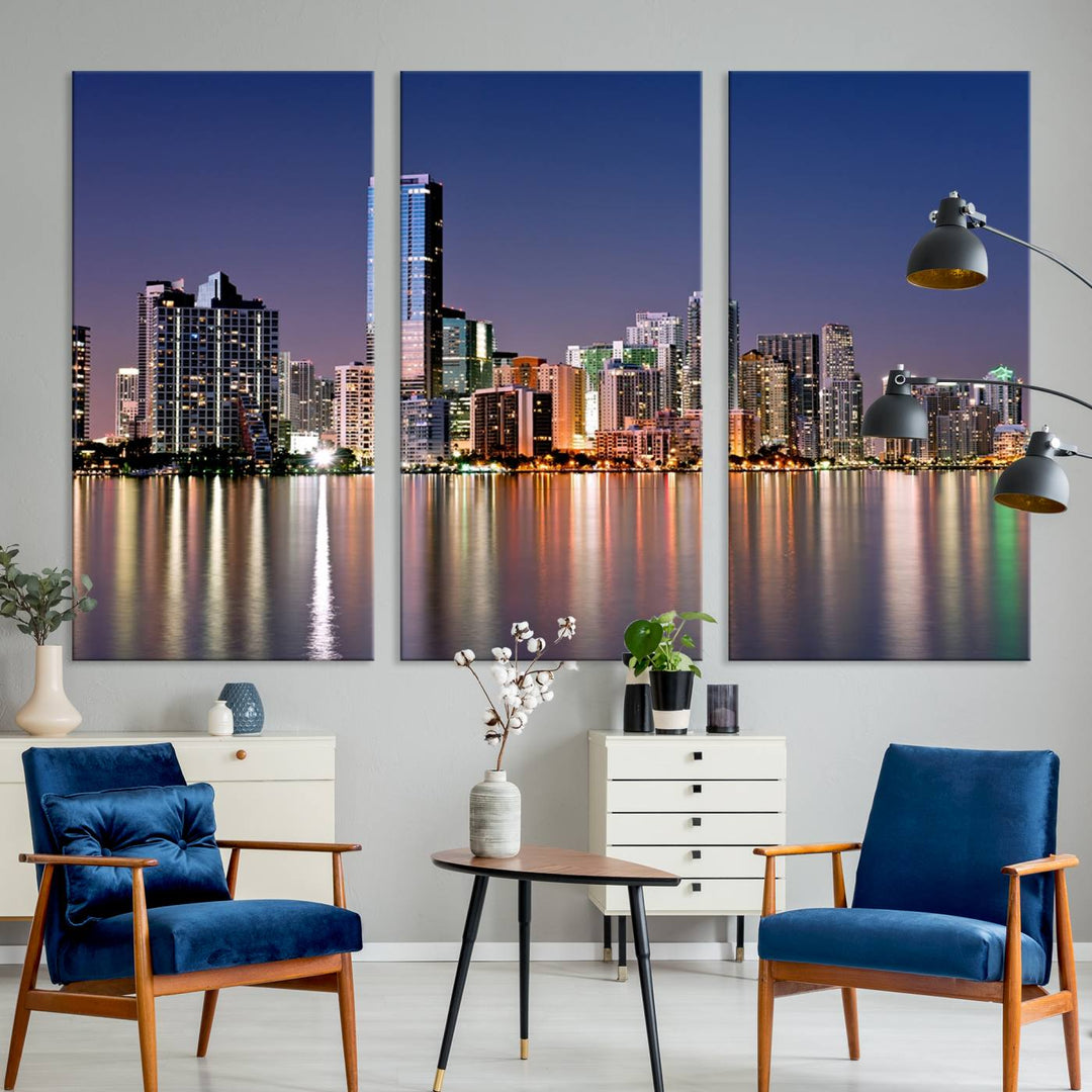 The Miami Skyline Canvas Wall Art Print showcases a vibrant night cityscape and beautifully captures the dazzling colorful lights reflecting on the water. This ready-to-hang triptych adorns the wall, creating a stunning visual centerpiece.