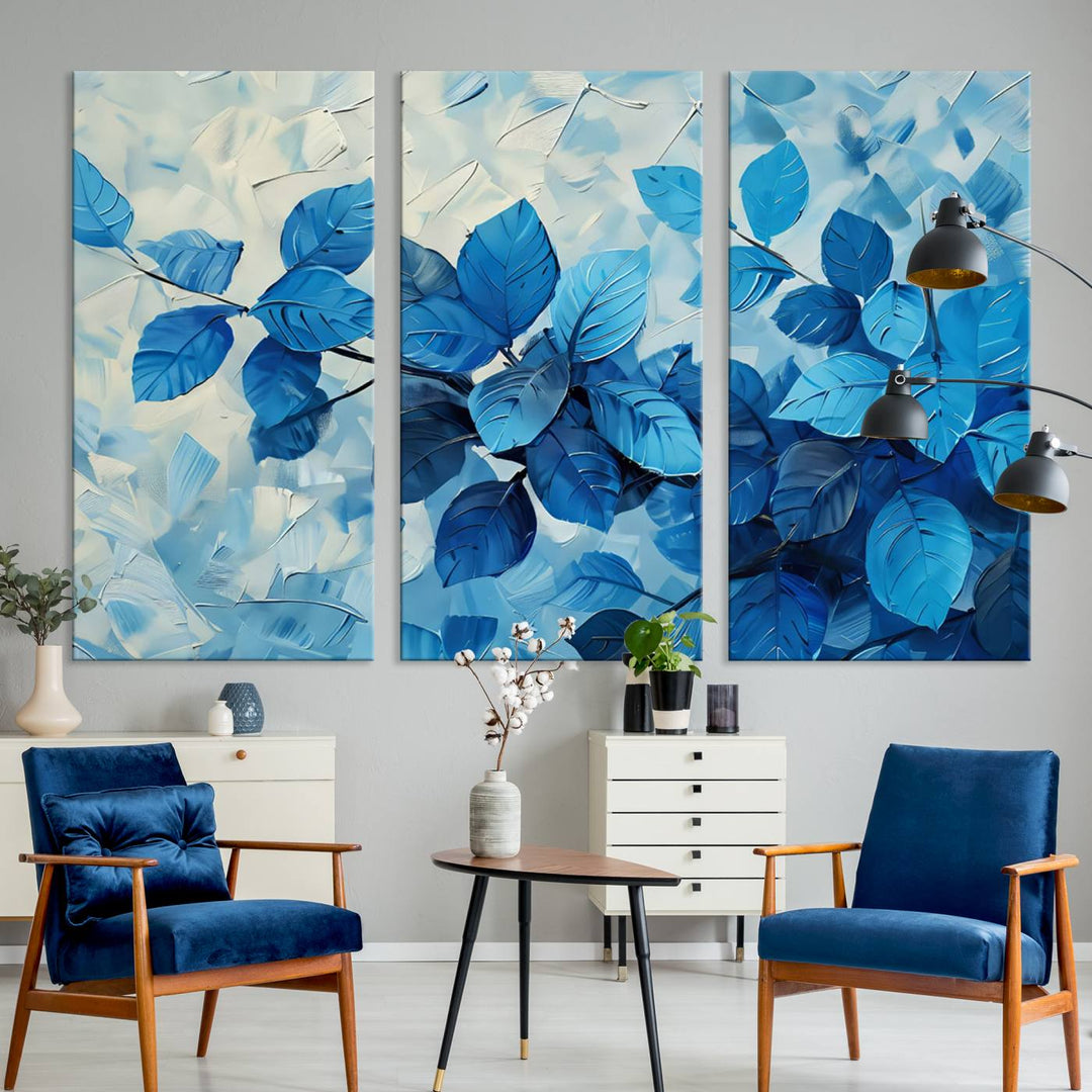 The contemporary living room is highlighted by the Abstract Blue Leaf Wall Art Canvas Print on the wall. The hand-assembled framed art enhances the room's vibrant decor, crafting a gallery-worthy ambience.