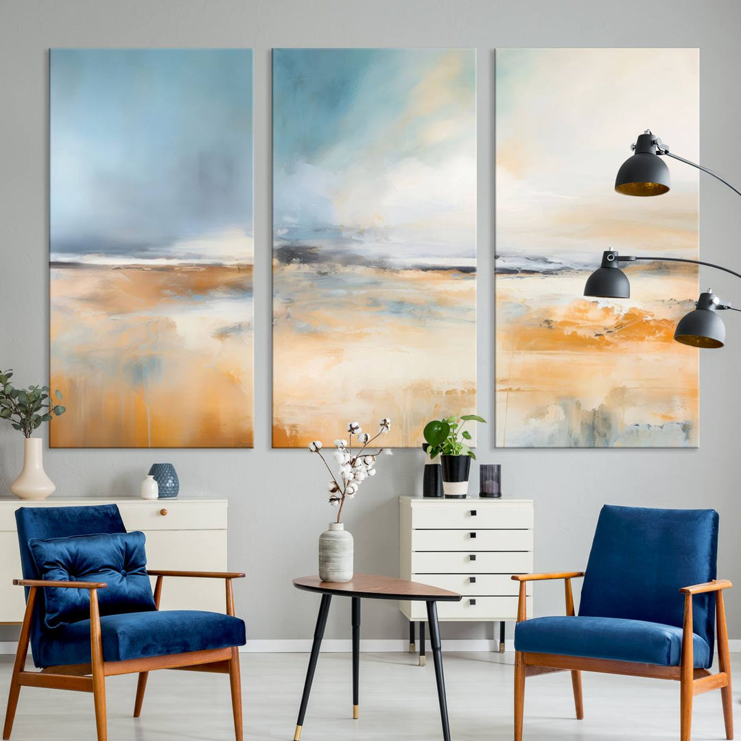 The Abstract Landscape Wall Art Canvas Print, featuring warm tones of orange and blue, is displayed on a dark wall.