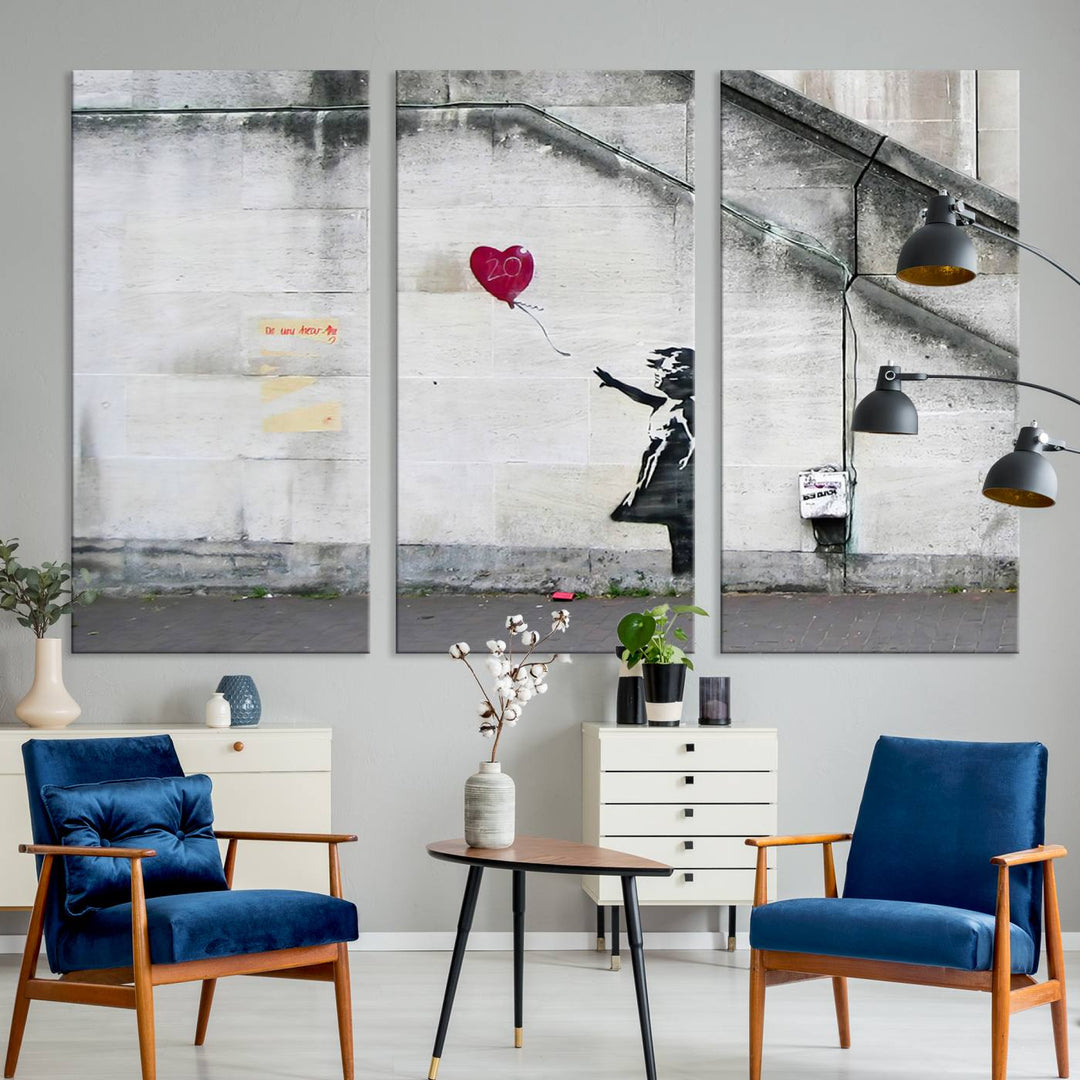 The "Girl with a Balloon Banksy Street Graffiti Art Canvas Print" is a gallery-quality wall art piece that features an image of a girl releasing a heart-shaped balloon. Handmade in the USA, this canvas artwork brings charm and emotion to any room.