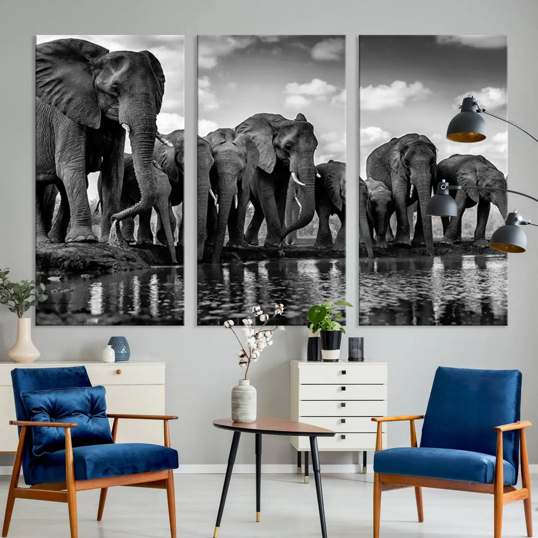 A stunning "Wall Art Animal Canvas Print" featuring a black and white photo of a herd of elephants drinking water is elegantly displayed, gallery wrapped on museum-quality canvas.