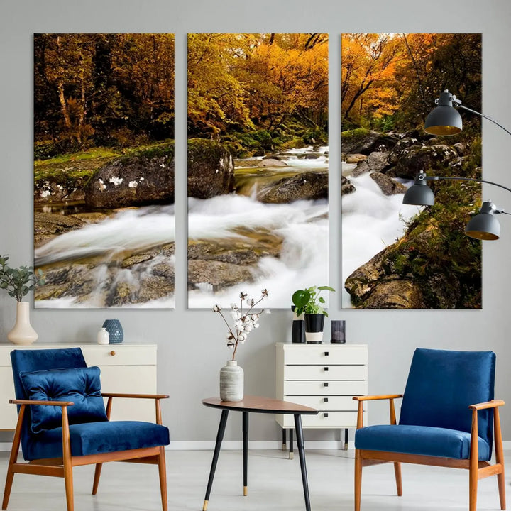 The living room is adorned with the "Wall Art Waterfall Canvas Print River in Forest in Autumn," a triptych on museum-quality canvas showcasing a flowing river surrounded by autumn trees. This ready-to-hang artwork features a UV-protective coating to ensure enduring vibrancy.