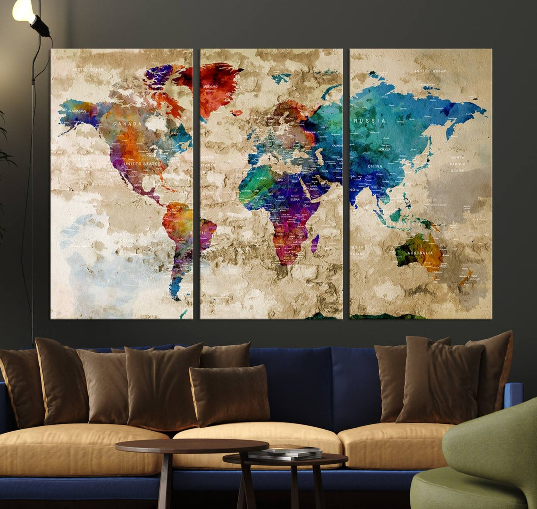 A triptych of world map decor, featuring a large, abstract watercolor canvas print with giclée printing for vibrant detail, hangs prominently. This Abstract Watercolor World Map Canvas Print adds a splash of color to modern living room interiors.