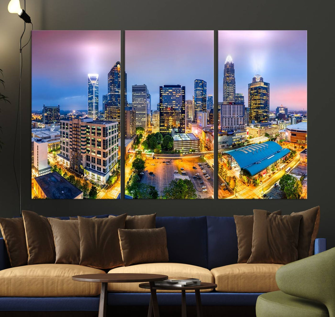 The living room features three large pieces of the *Charlotte City Lights Sunset Purple Skyline Cityscape View Wall Art Canvas Print*. Crafted on gallery-wrapped, museum-quality canvas with UV-protective coating, they grace the wall and add an artistic flair to the space.