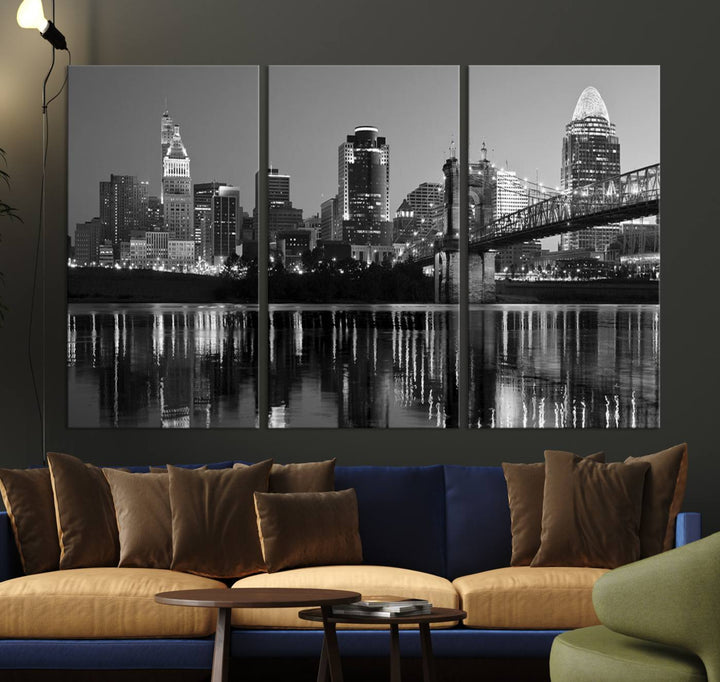 The wall showcases a ready-to-hang triptych of the Cincinnati City Lights Skyline in black and white, printed on museum-quality canvas.