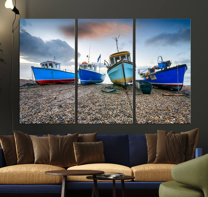 The "Big Boats On The Beach Wall Art Canvas Print" is a stunning piece featuring three museum-quality panels depicting fishing boats on a pebbled shore. Ready to hang and featuring UV-protective coating, it serves as an elegant addition to your home décor.