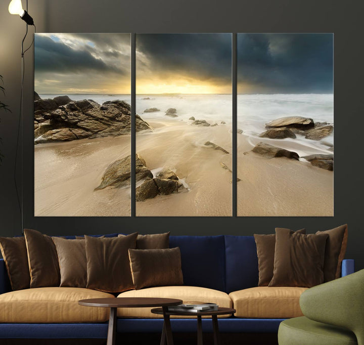 A gallery-wrapped, three-panel artwork titled "Rocks and Waves Wall Art Canvas Print" depicts a rocky beach at sunset. Each canvas showcases museum-quality craftsmanship and a UV-protective coating to maintain its vibrant colors.